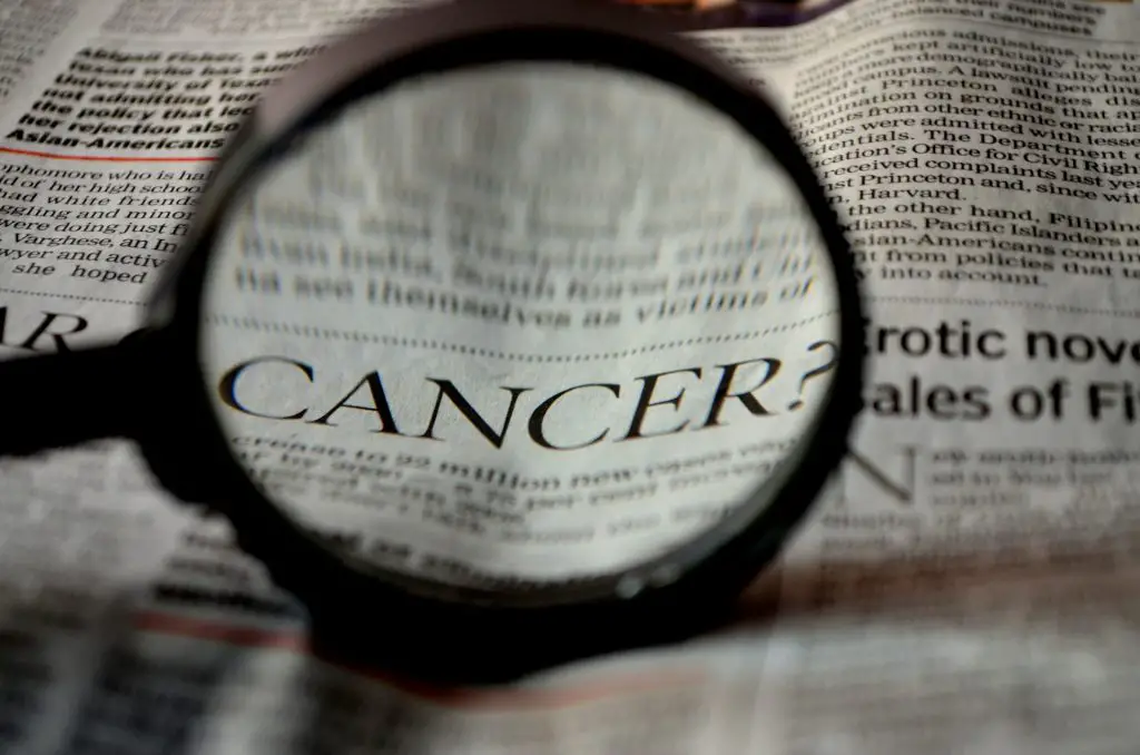 magnifying glass showing the word "Cancer"